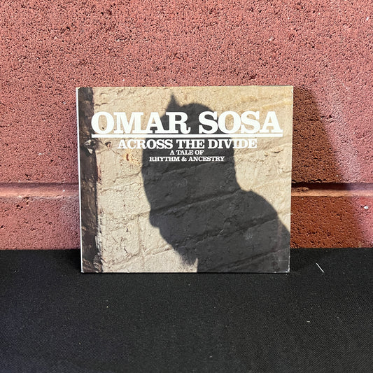Used CD: Omar Sosa ‎"Across The Divide: A Tale Of Rhythm & Ancestry" CD